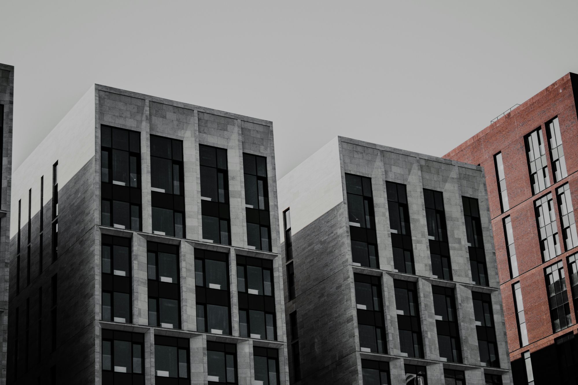 Grounded luxury architecture with charcoal stone and deep terracotta exterior.